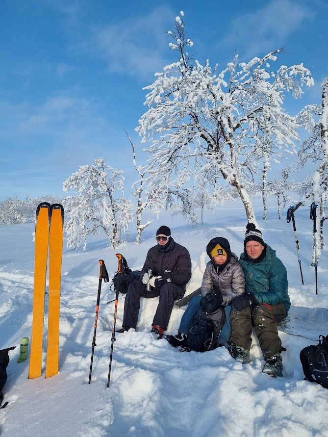 En grupp människor som sitter på toppen av ett snötäckt fjäll
