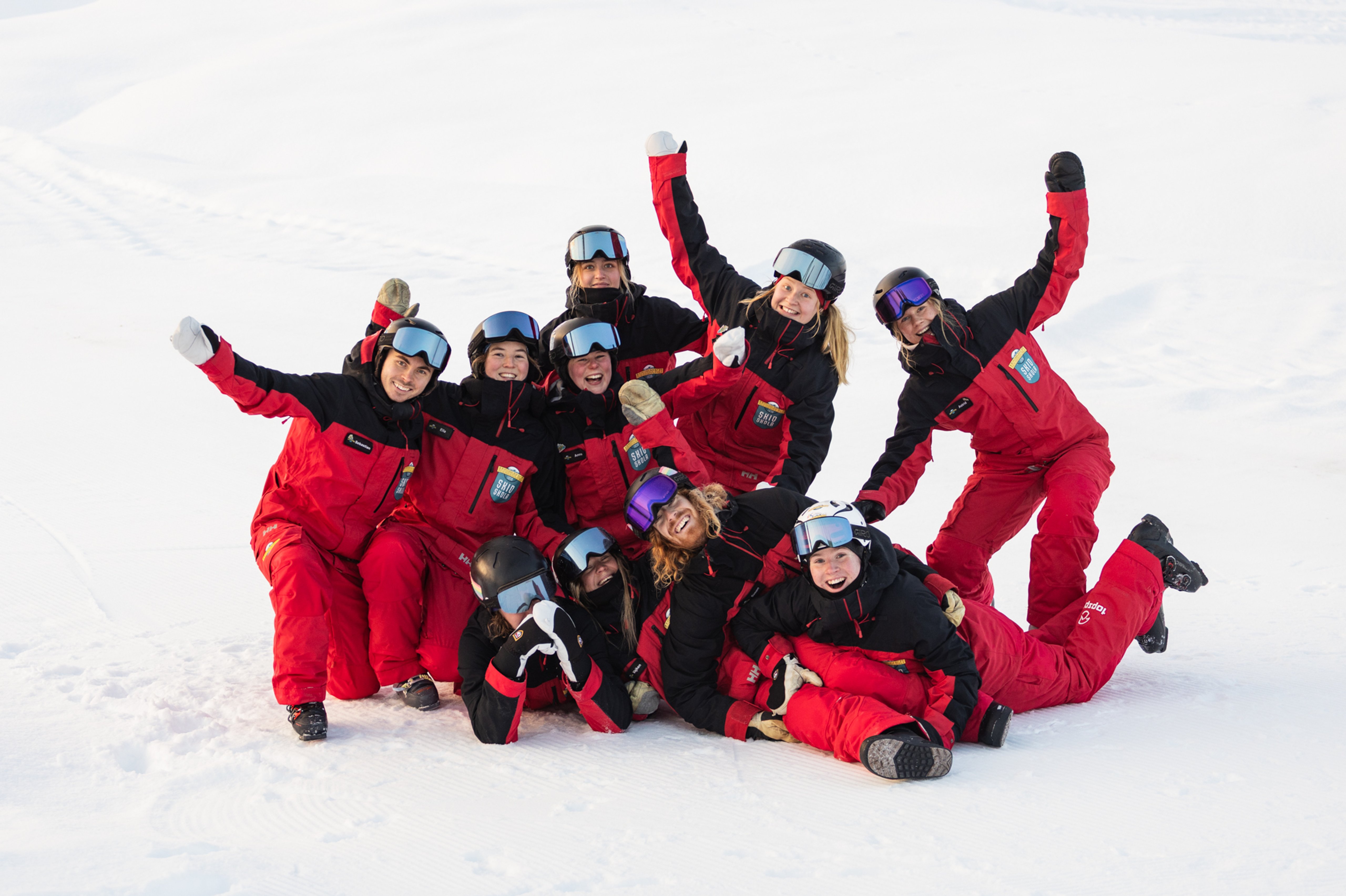 A group of ski instructors pose for a photo in the snow.