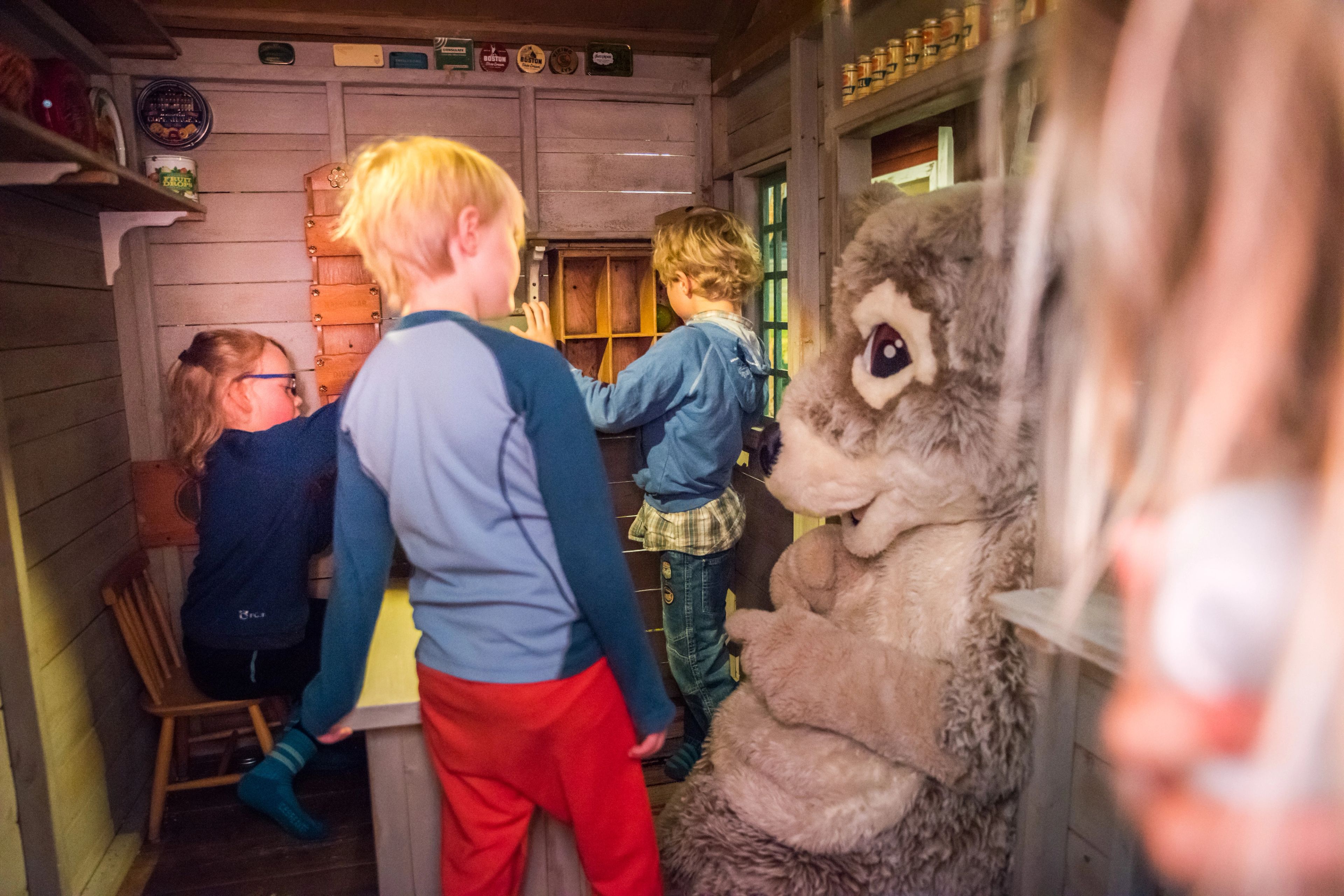 En grupp barn som står runt maskoten Mickelina fjällräv.