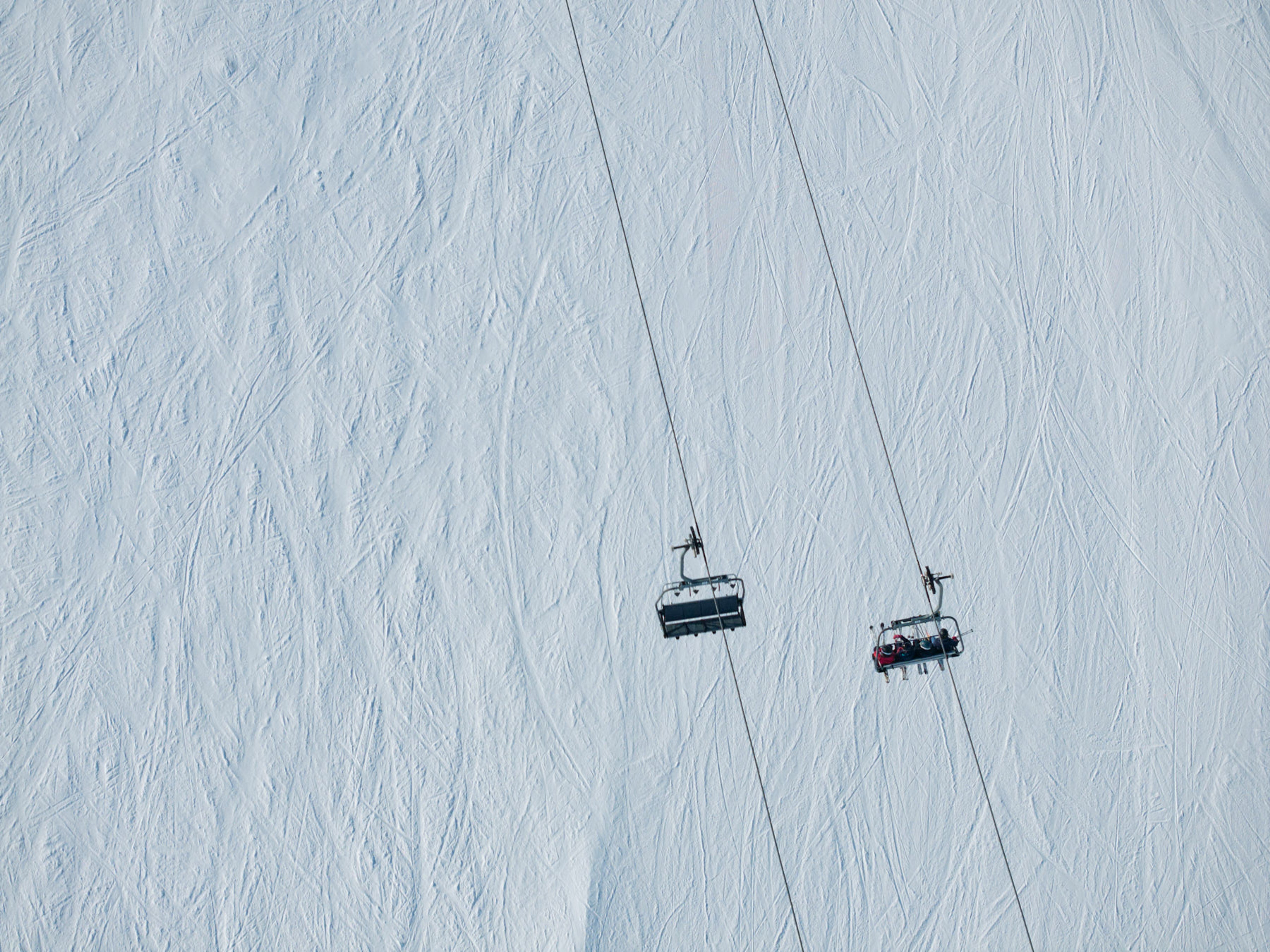 A ski lift ascending a snow-covered mountainside.