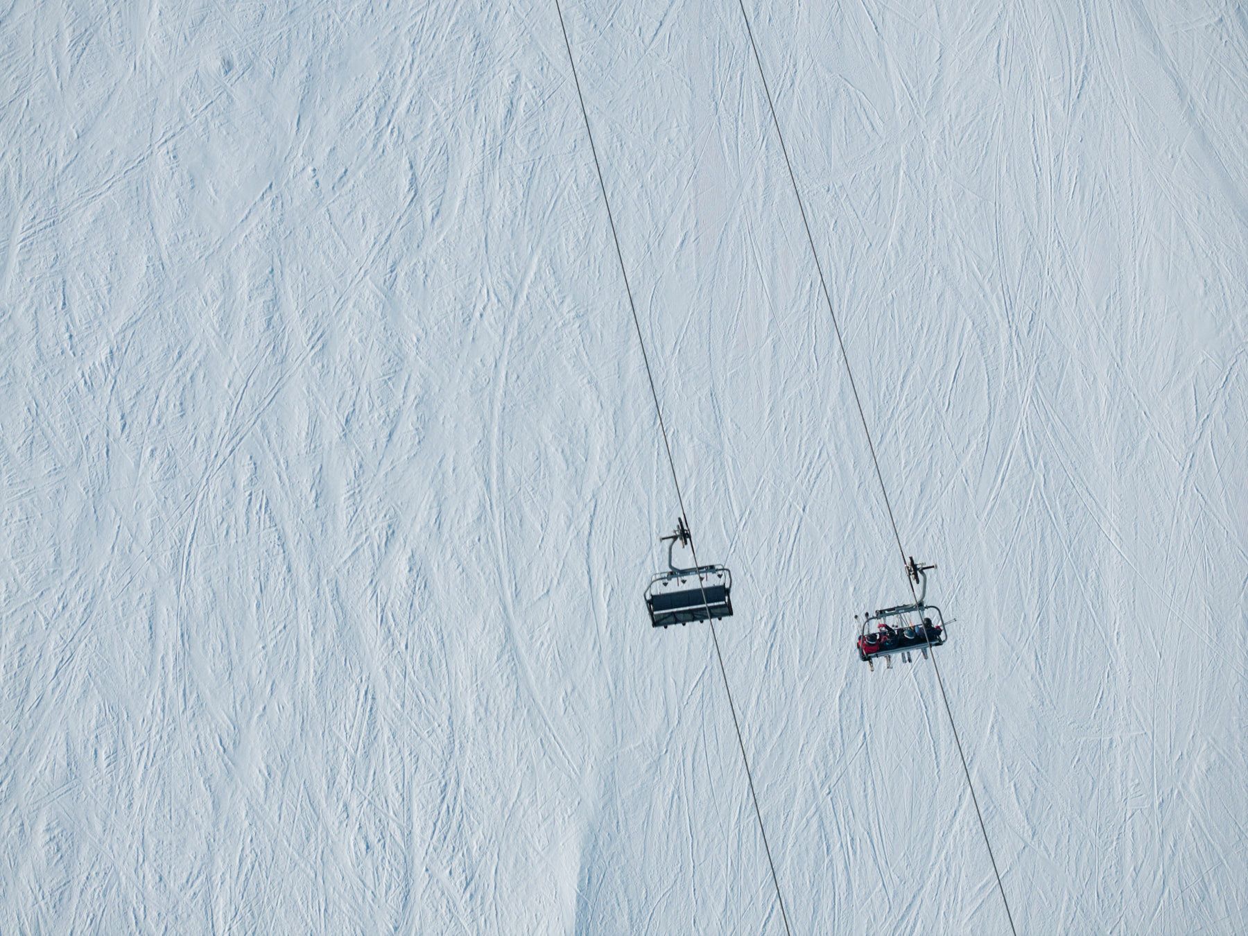 En skidlift som går uppför en snötäckt bergssluttning.