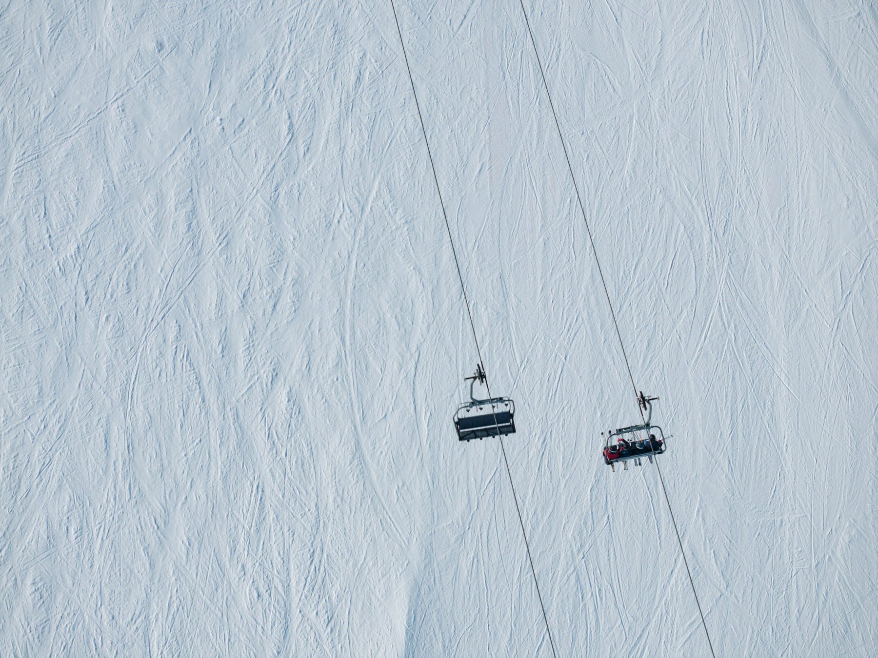 A ski lift ascending a snow-covered mountainside.