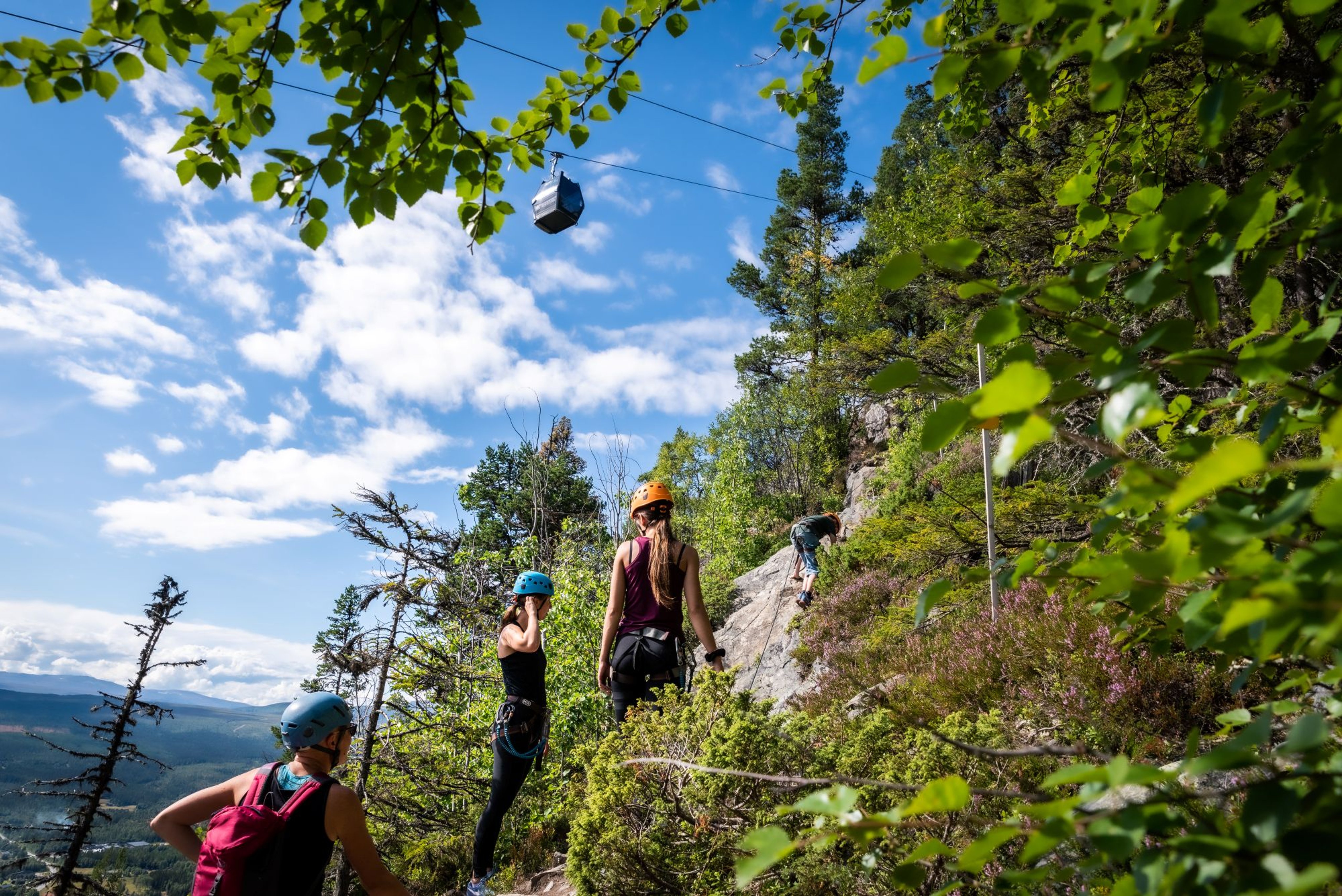 A few people walking up a rocky mountainside.
