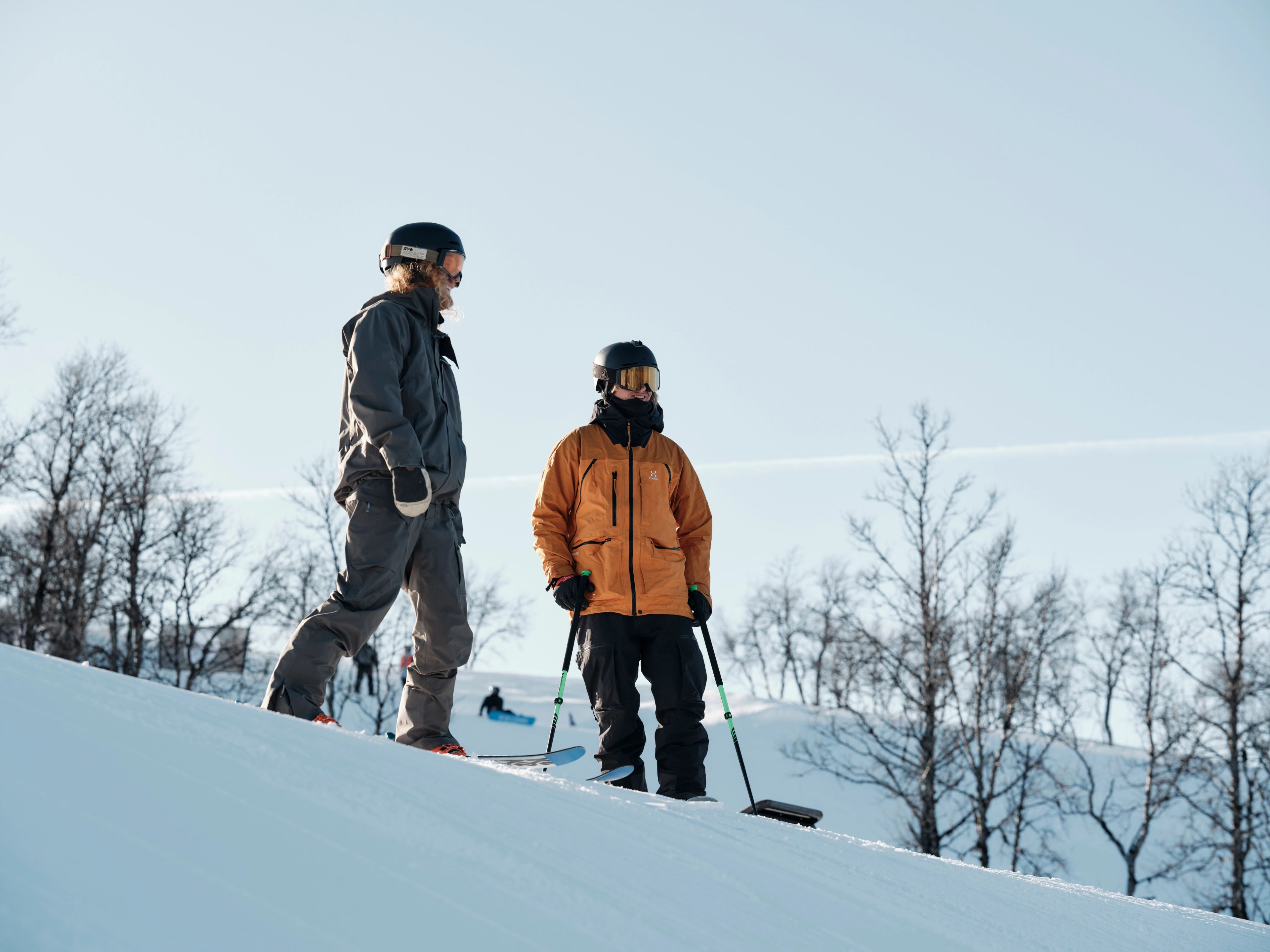 Några män på skidor som står på toppen av en snötäckt sluttning.