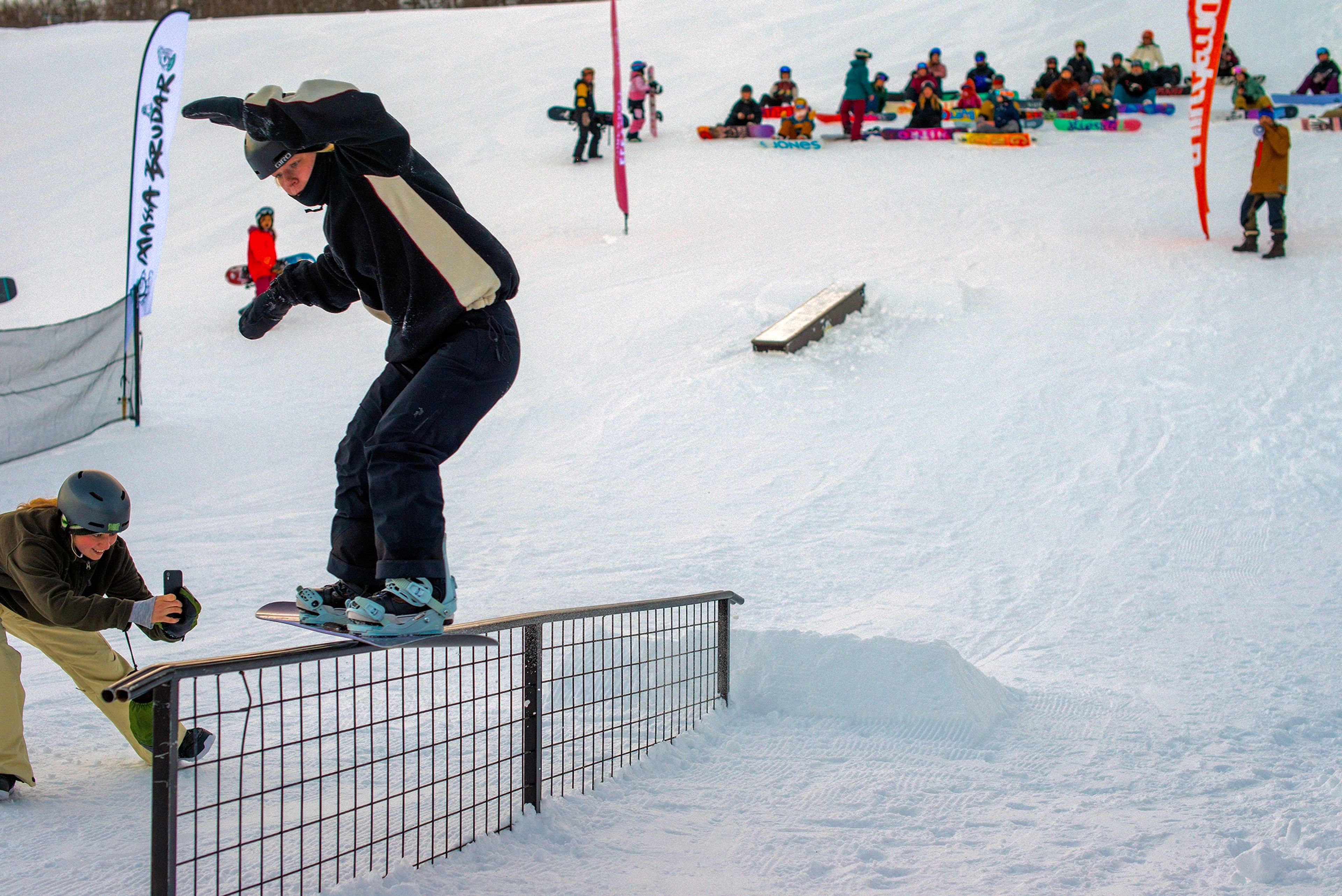 En kvinna som åker snowboard på en rail