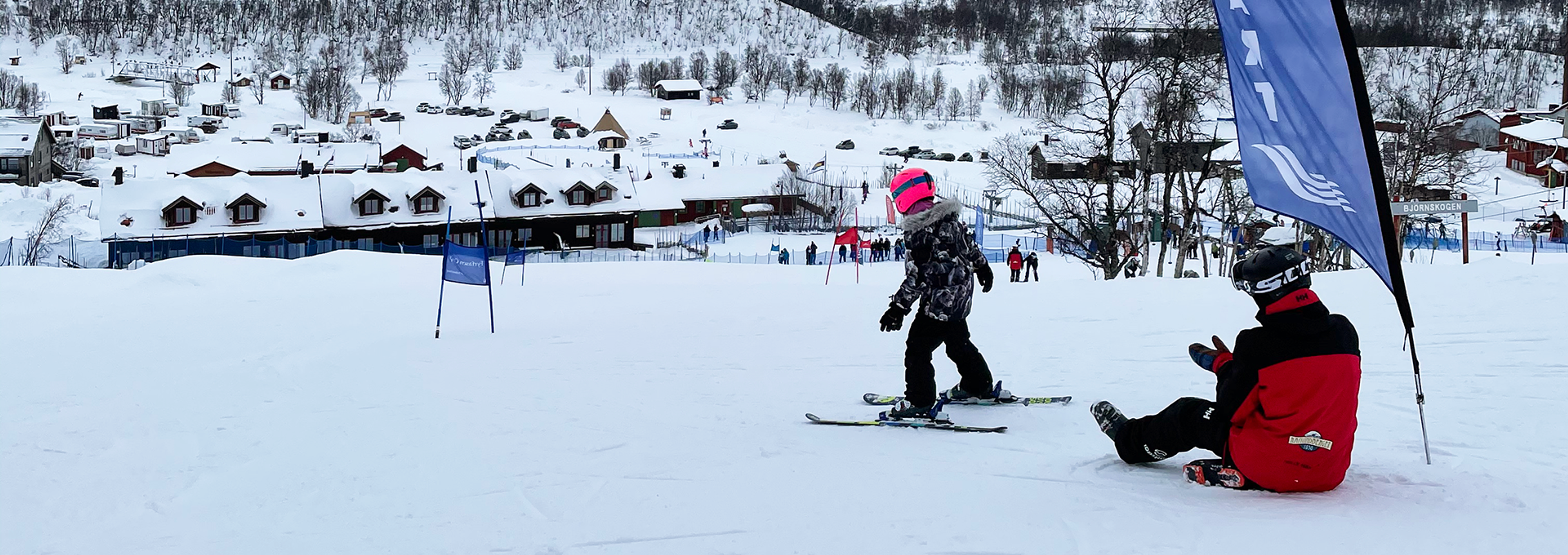 Ett barn som åker skidor nedför en snötäckt sluttning.