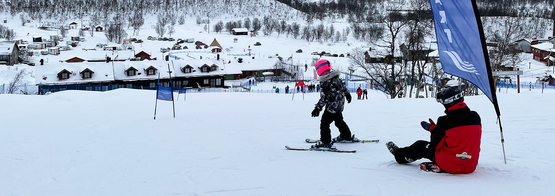 Ett barn som åker skidor nedför en snötäckt sluttning.