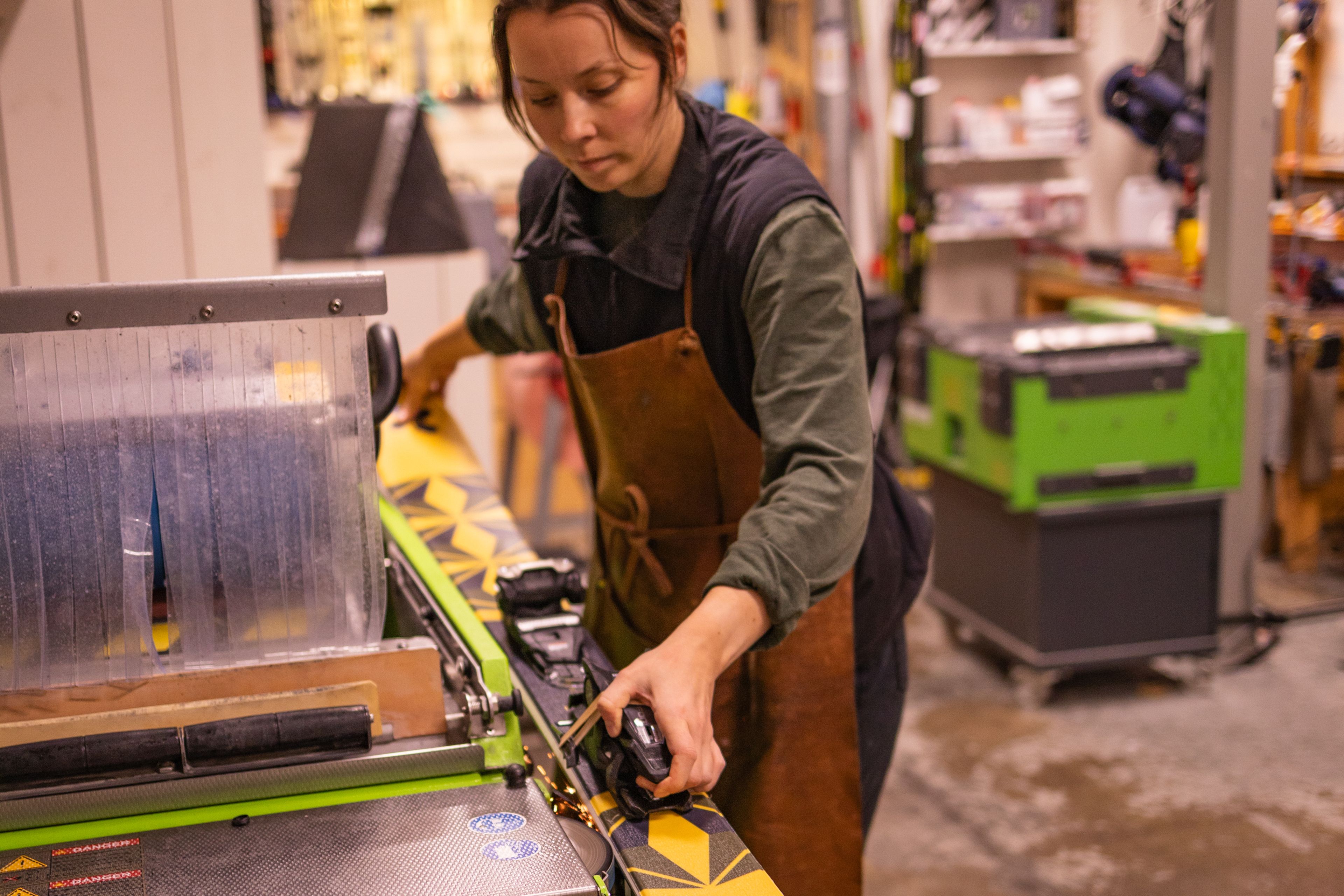A woman working at a machine in a workshop.