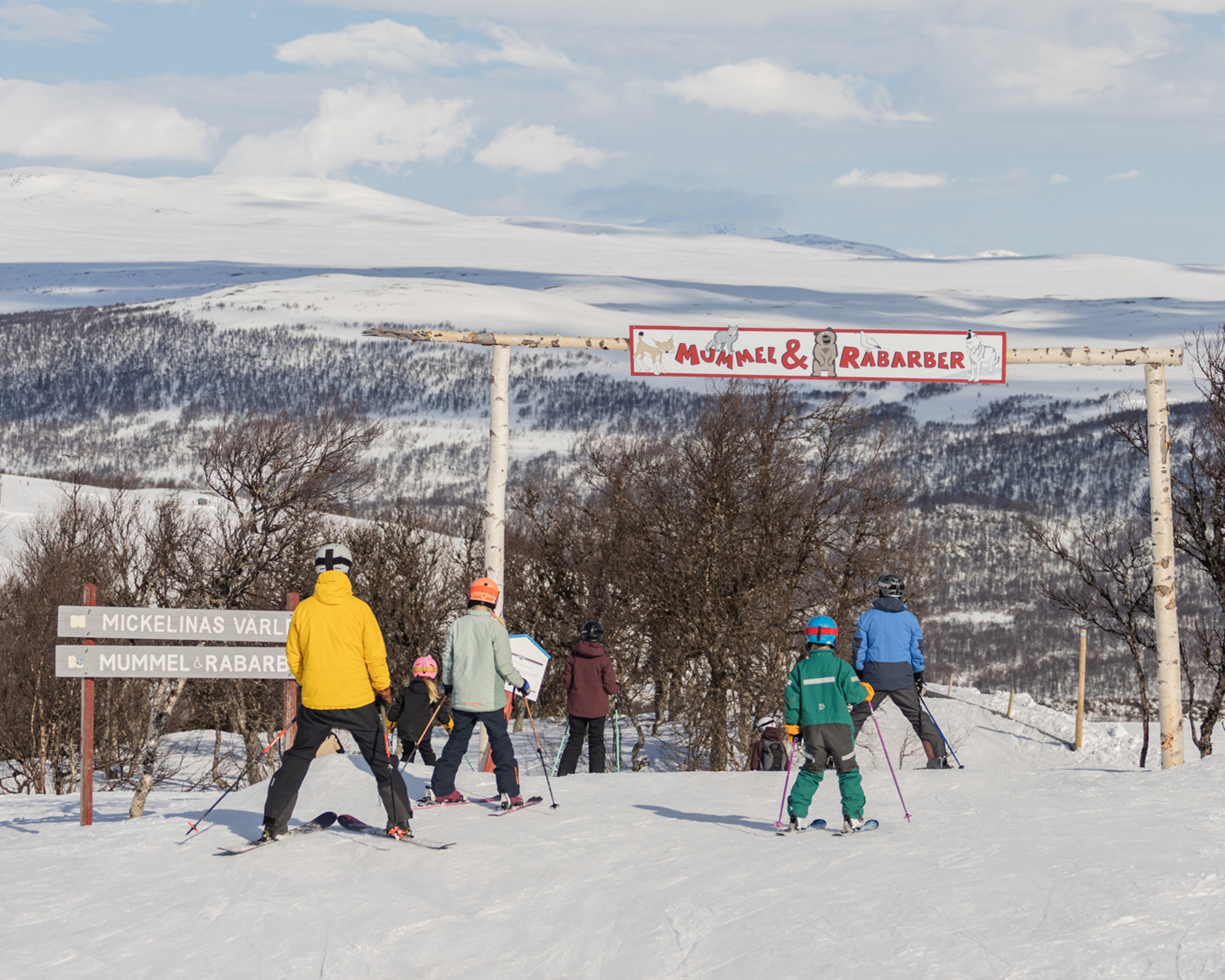 En grupp människor som står på toppen av en snötäckt sluttning.