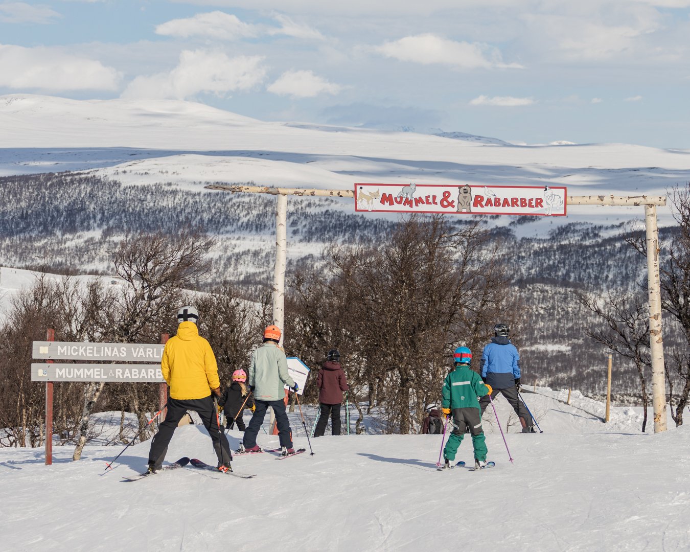 En grupp människor som står på toppen av en snötäckt sluttning.
