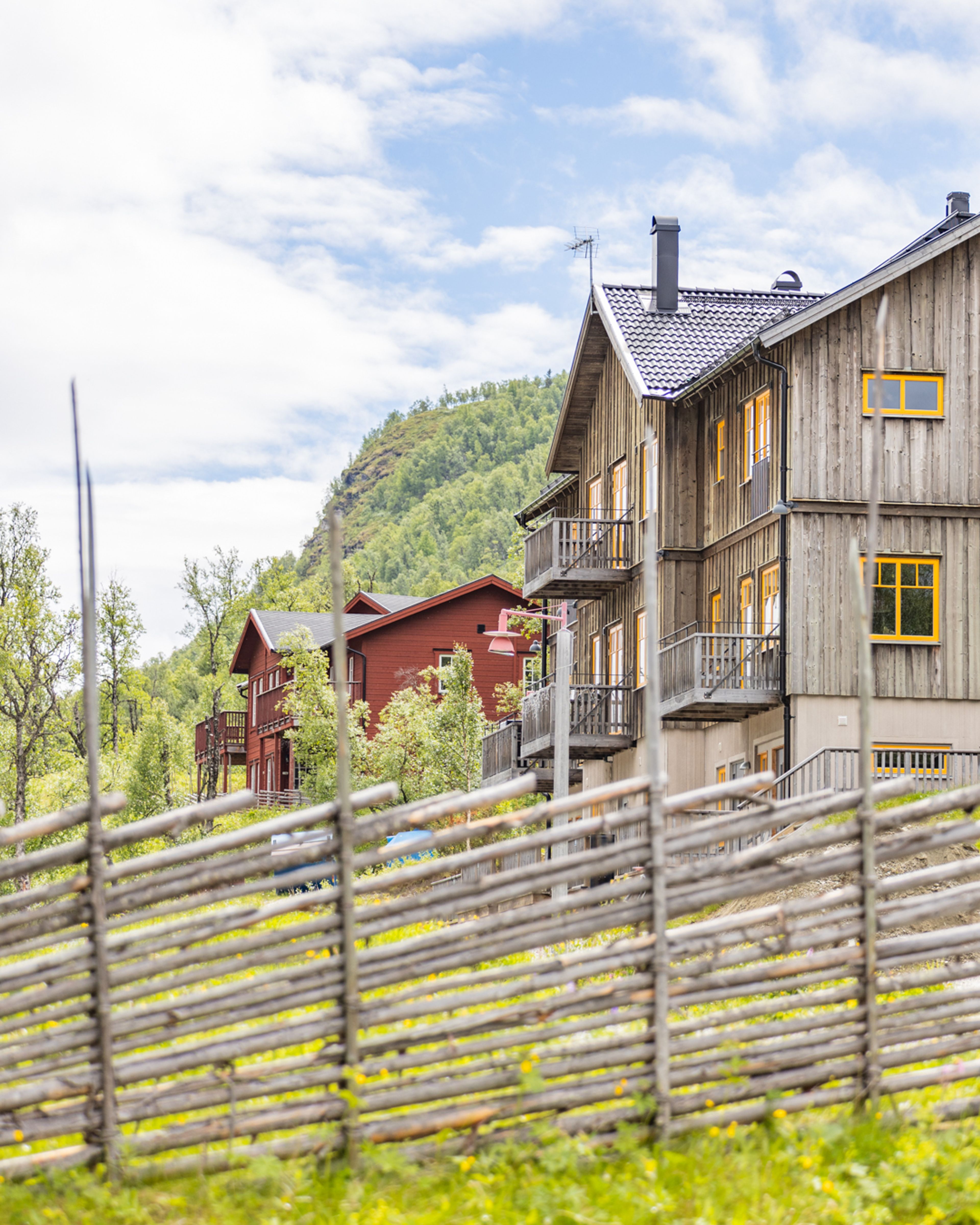 Ett hus med ett trästaket framför sig.