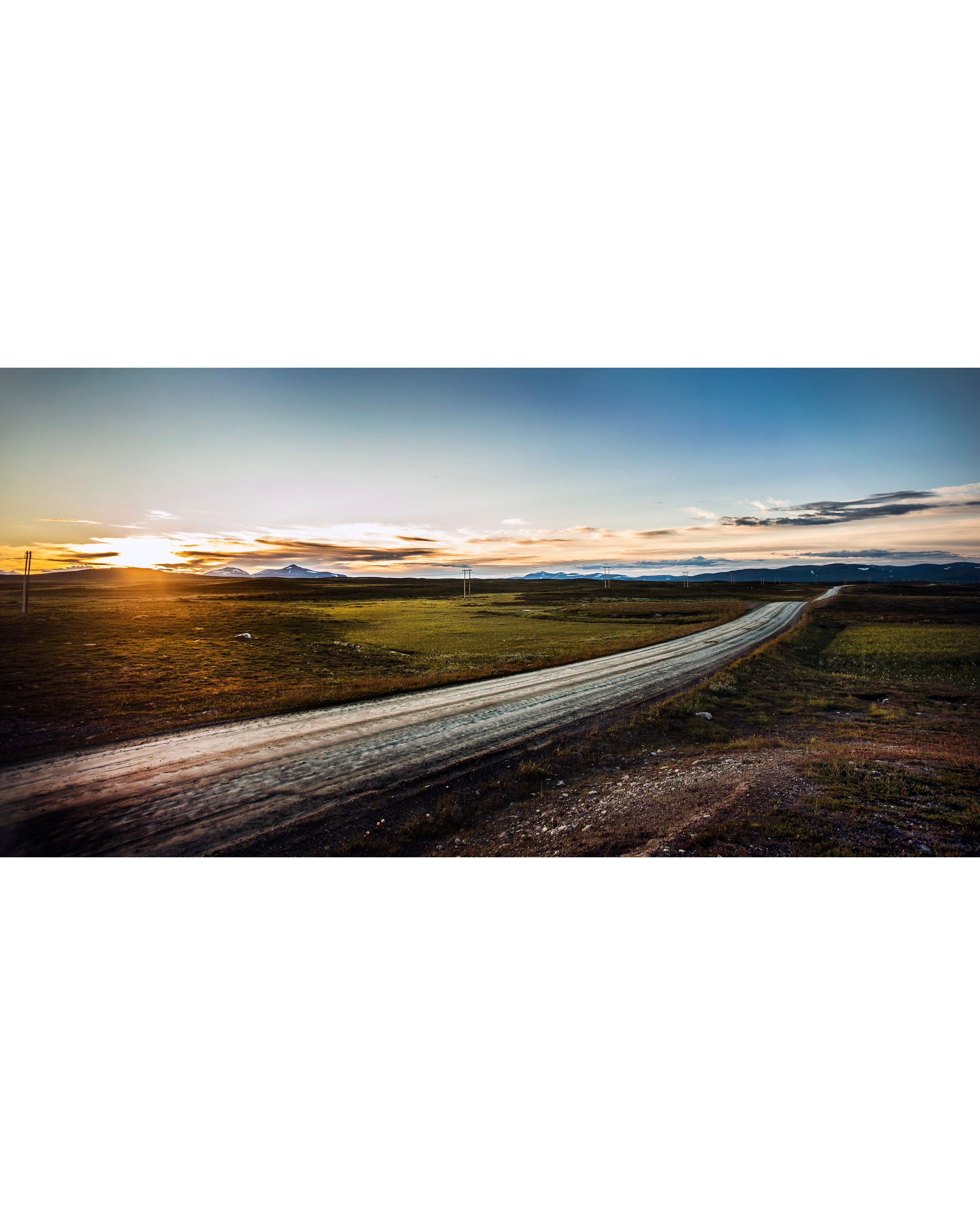 En grusväg mitt över Flatruet mellan fjäll.