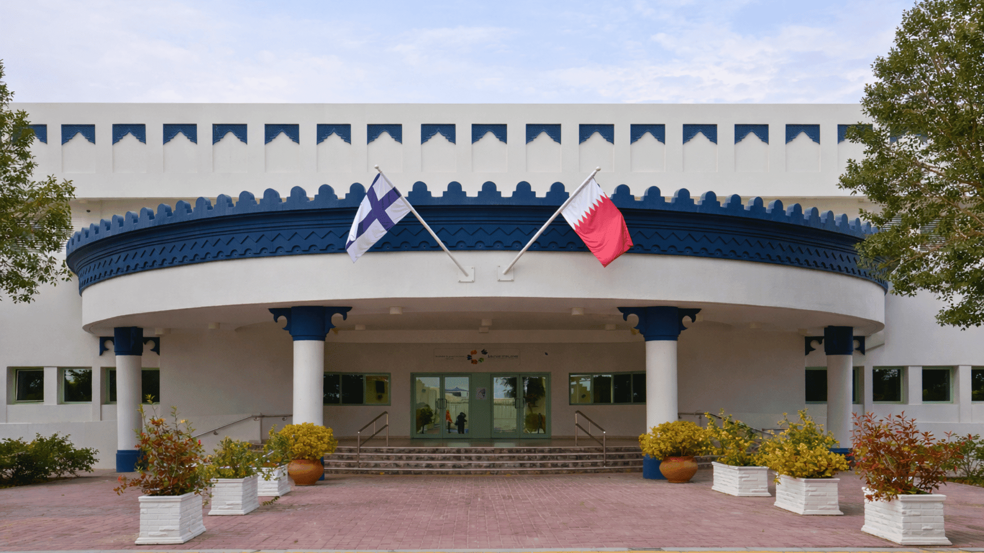 Qatar Finland International School exterior with Qatar and Finland flags