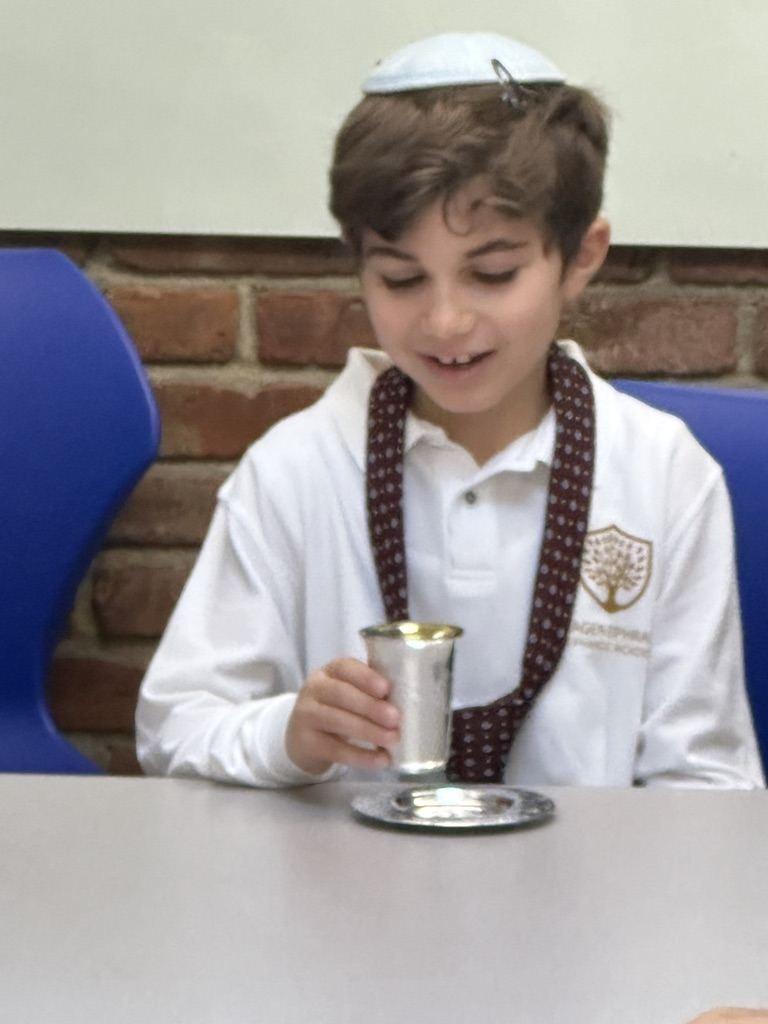 A student holding a kiddush cup