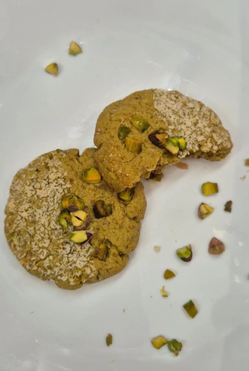 Pistachio millet cookie with a bite taken