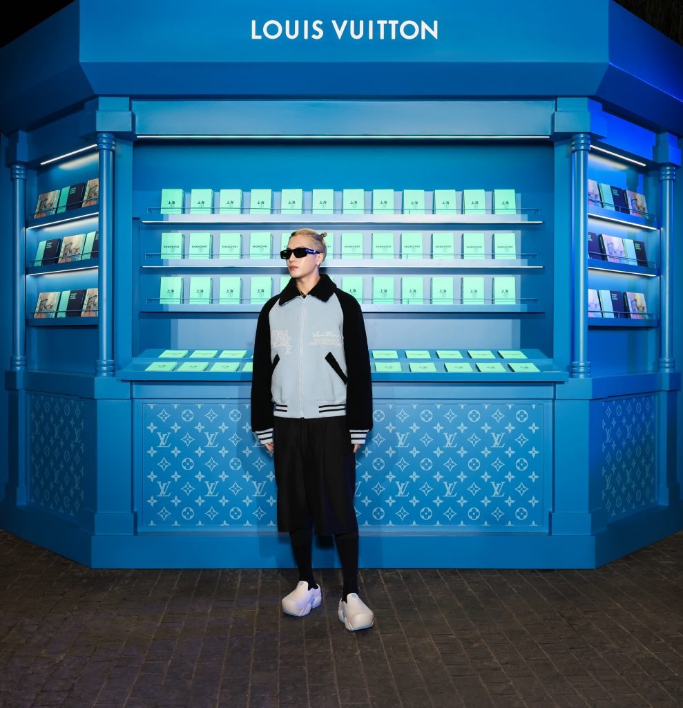 Louis Vuitton brand ambassador Jackson Wang stands in front of a book kiosk presenting the new edition of Louis Vuitton City Guide Shanghai. Photo: Louis Vuitton