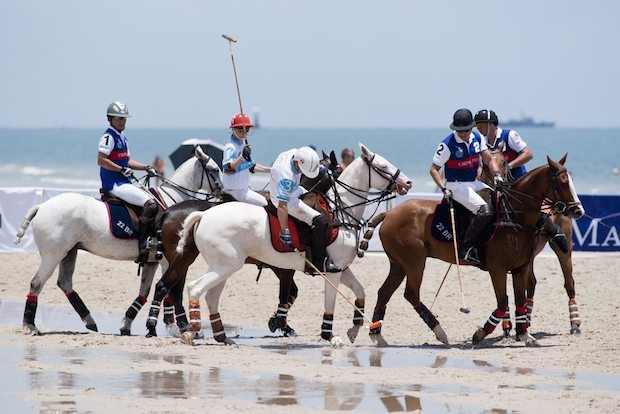 A Chinese polo team (blue jerseys) competes against a Thai team at a beach polo tournament in Hua Hin, Thailand. (Shutterstock)