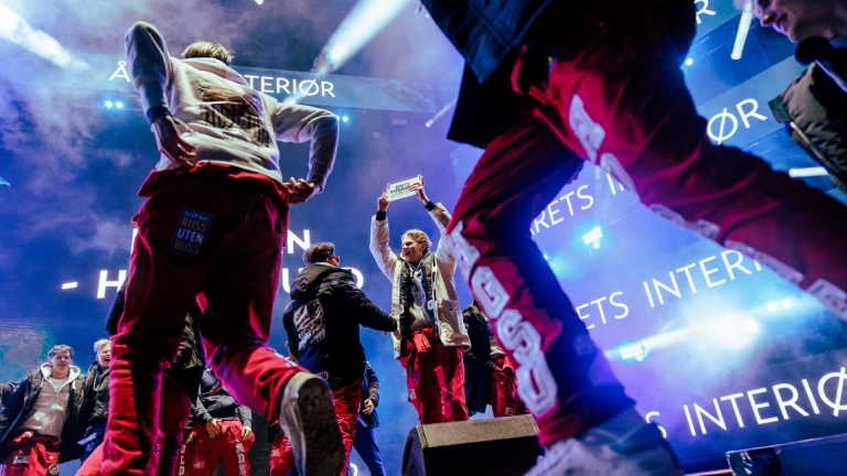 En bussgjeng feirer at de har vunnet en pris på LS på scenen.