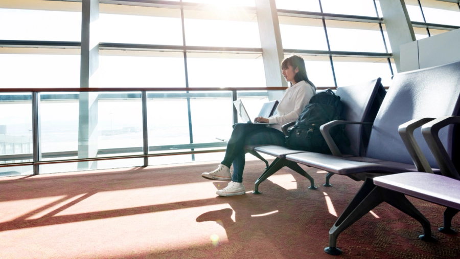 Woman sitting at airport on laptop