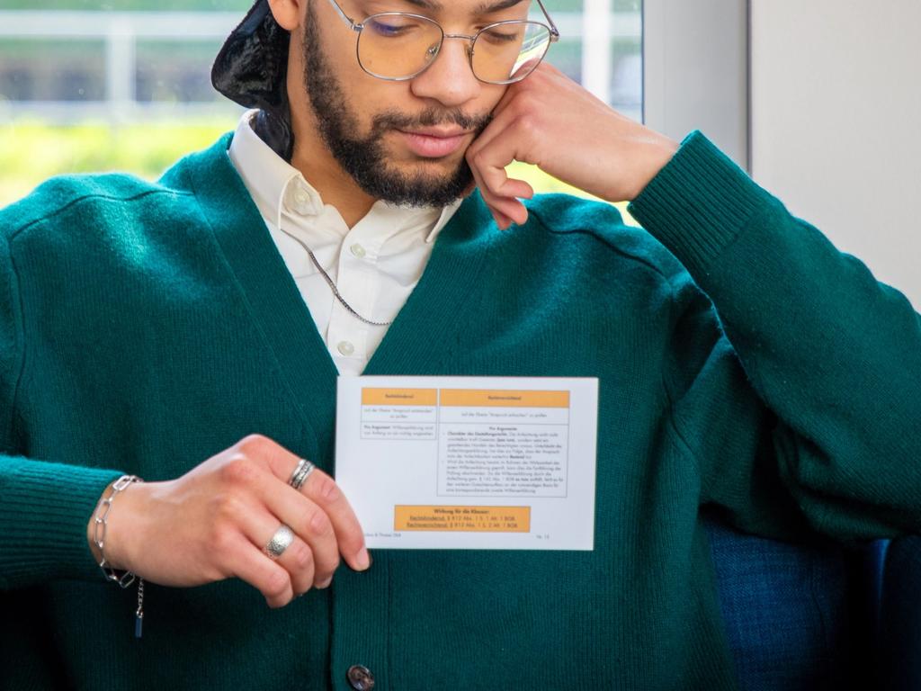 Jura-Student hält eine Jurakompakt-Karteikarte in die Kamera