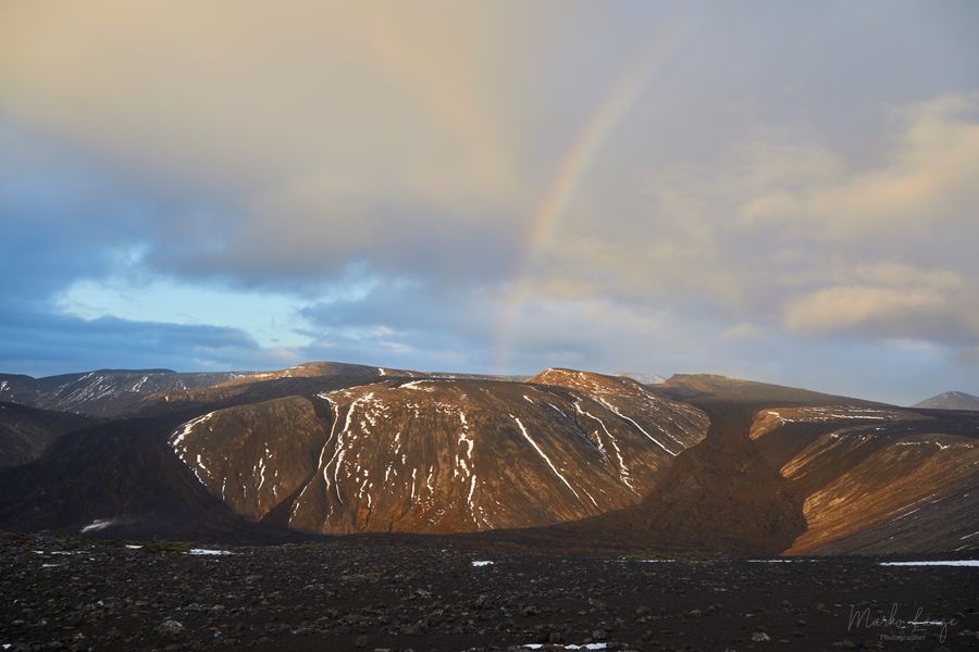 Regenbogen über schwarzem Lavafeld