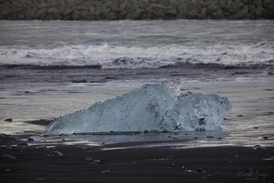 Eisstücke am schwarzen Strand