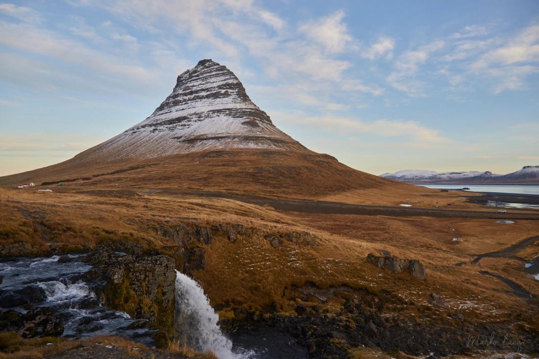 Der Kirkjufell erhebt sich als steiler, geschichteter Kegel über der winterlichen Küstenebene.