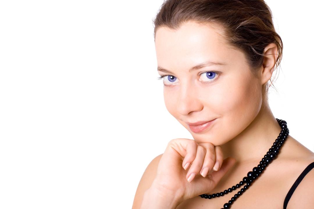 A woman with a necklace on her neck posing for a picture