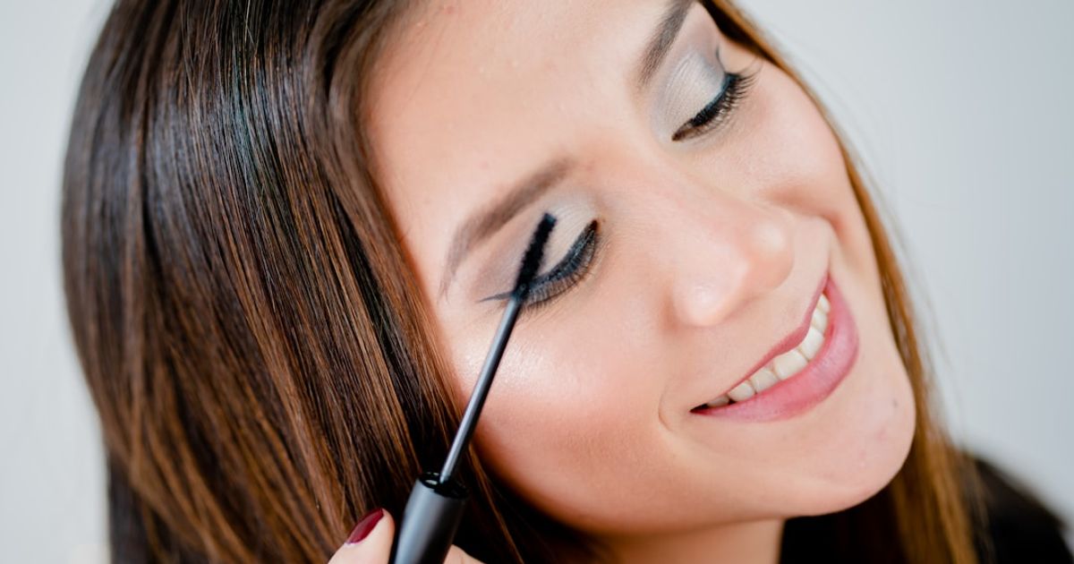 woman holding black pen smiling