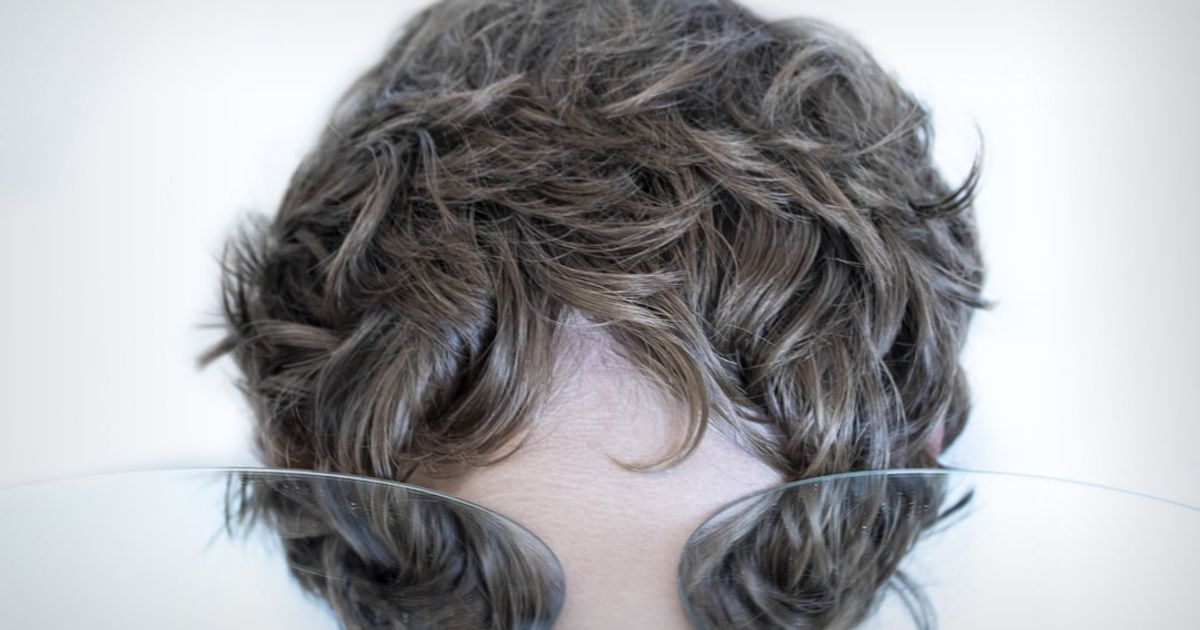 woman with brown hair covering her face