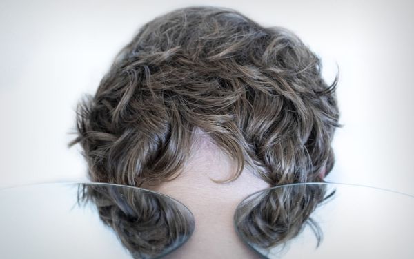 woman with brown hair covering her face