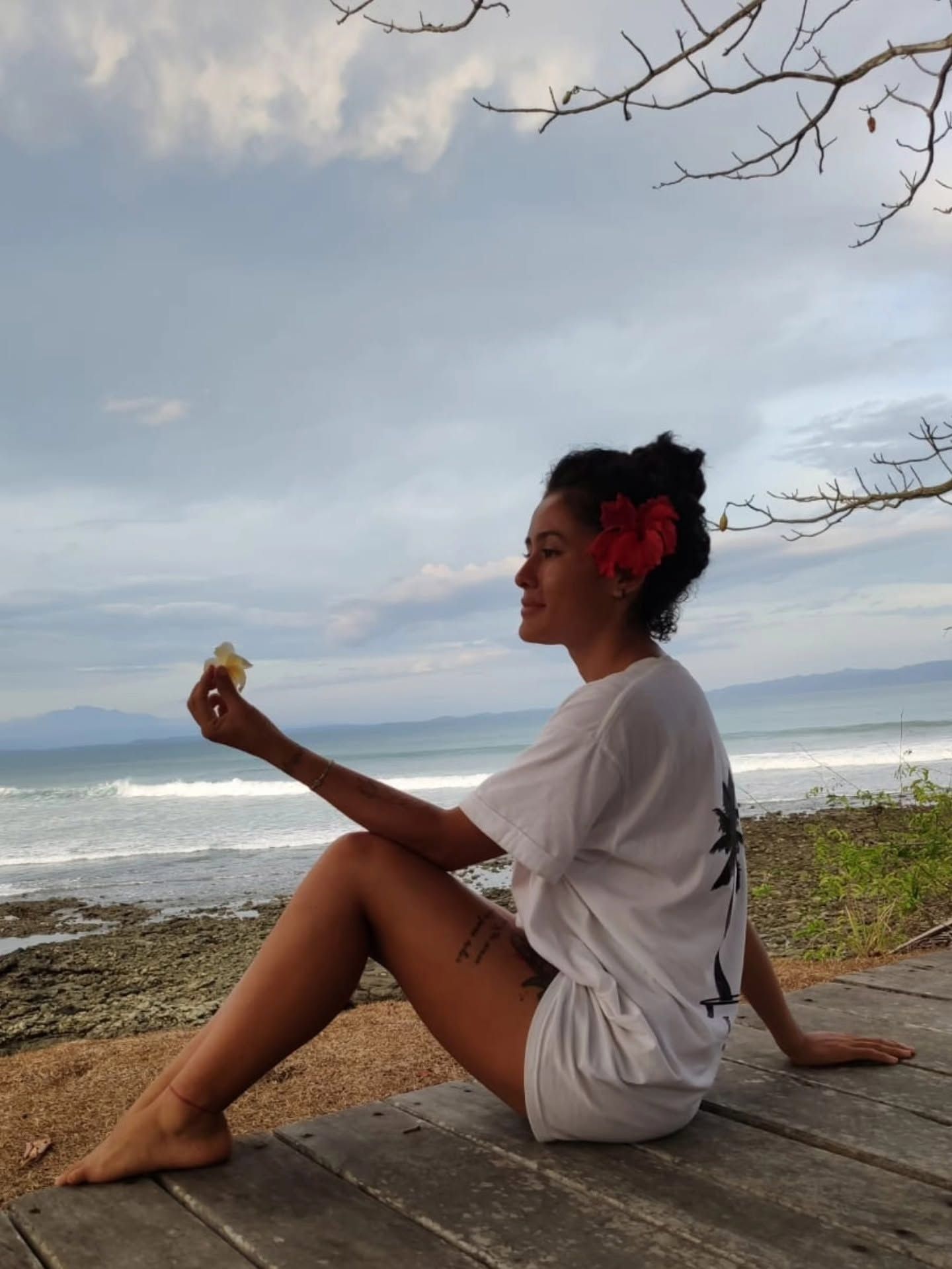 Verónica sitting on a wooden deck by the ocean