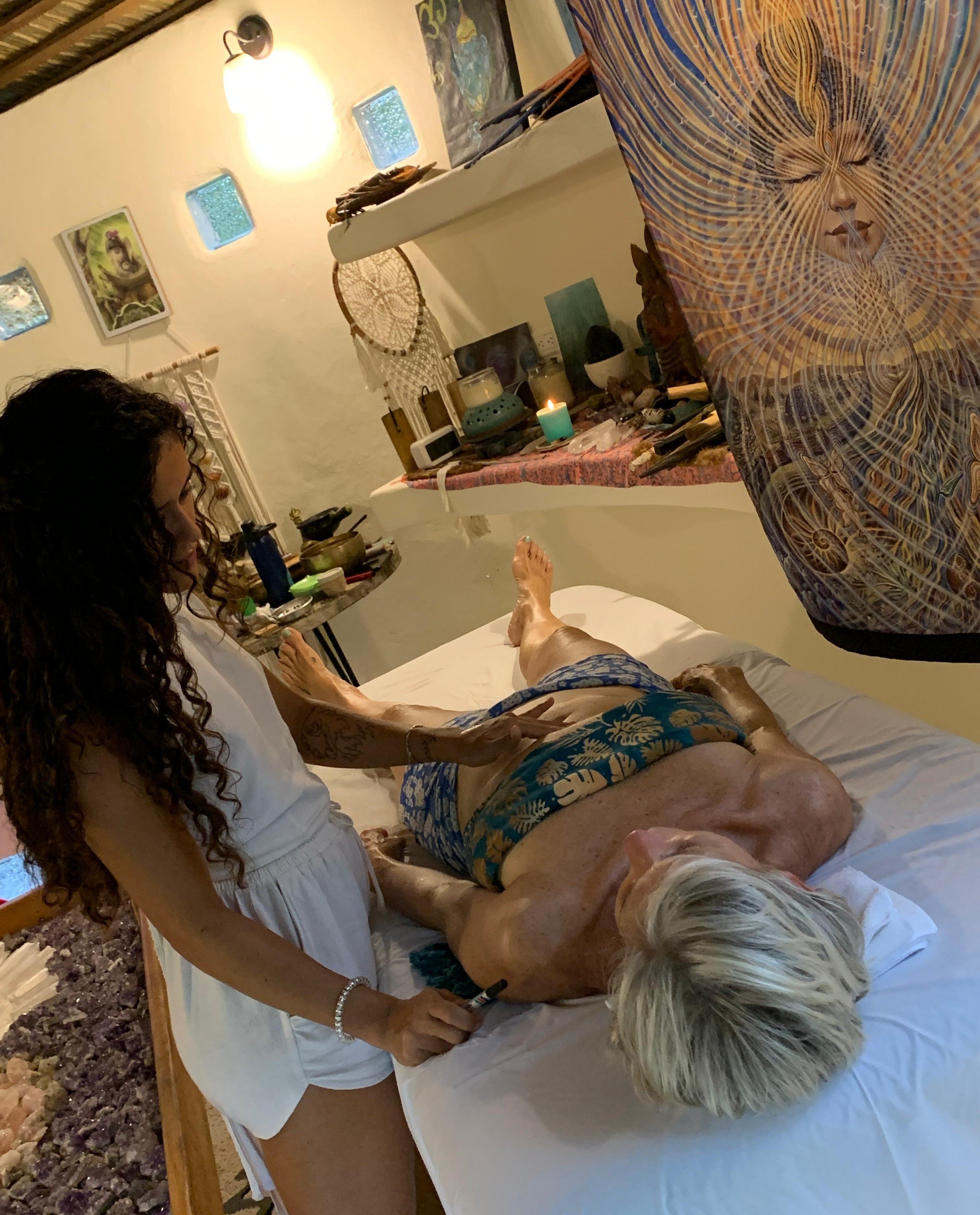 Practitioner applying pressure to a client's face during a group treatment