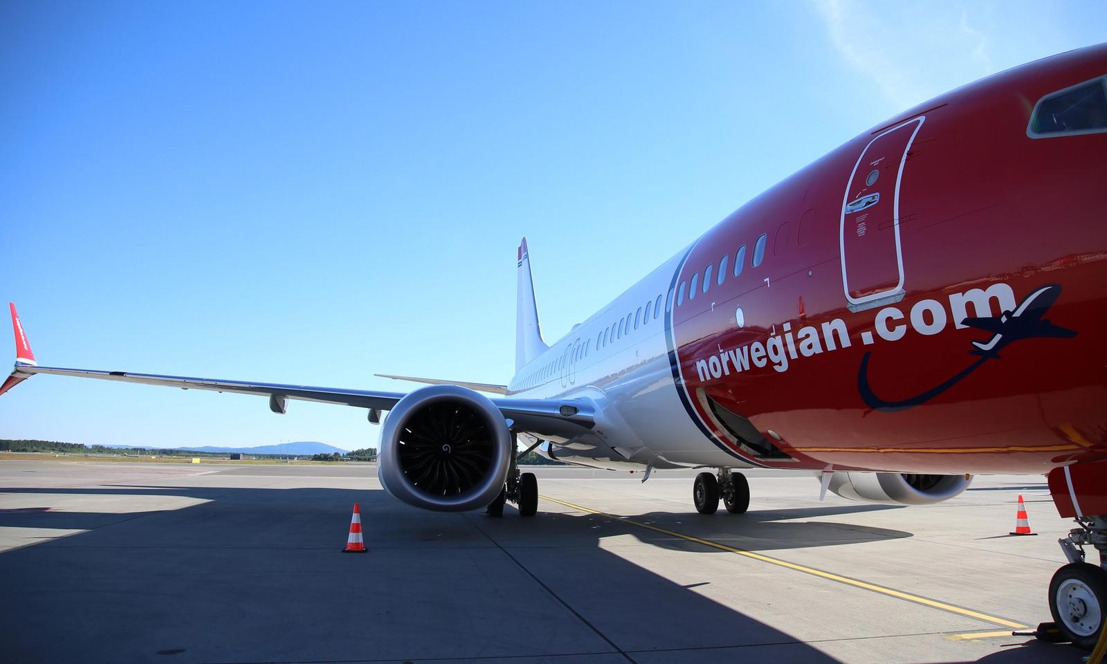 विमानस्थलमा पार्क गरिएको Norwegian को रातो र सेतो रङको यात्रुवाहक विमान