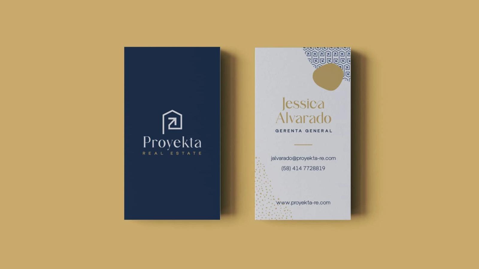 Tarjetas de presentación vertical para Proyekta Real Estate mostrando el logotipo sobre fondo azul oscuro y el reverso con diseño minimalista en blanco incluyendo cargo y elementos gráficos dorados