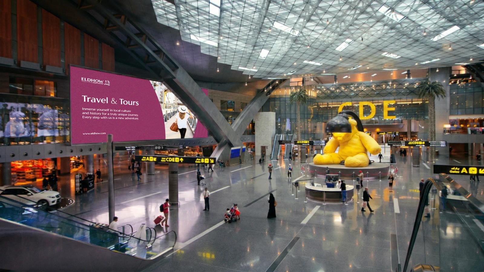 Espacio amplio tipo aeropuerto con publicidad digital de marca
