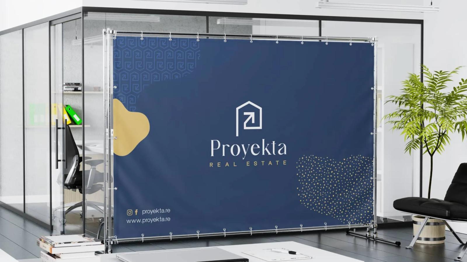 Banner corporativo de marca inmobiliaria instalado en espacio de oficina moderna con diseño elegante