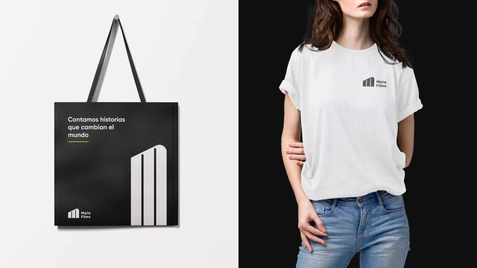 Mockup de merchandising de Maia Films mostrando una bolsa negra con el eslogan Contamos historias que cambian el mundo y una mujer usando una camiseta blanca corporativa con el logotipo en el pecho