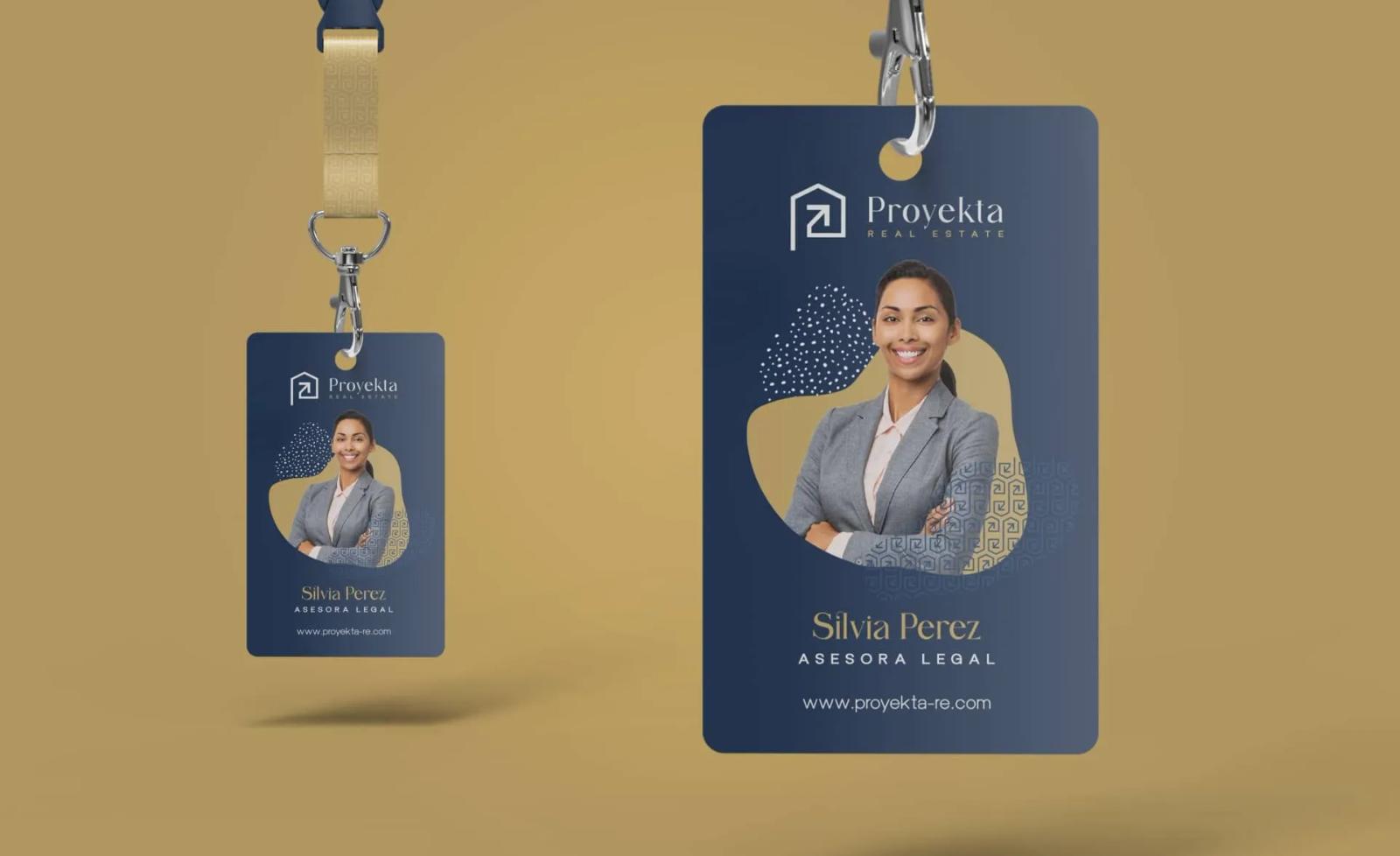 Carnet de identificación corporativo para Proyekta Real Estate en azul oscuro con elementos gráficos dorados mostrando la fotografía de una profesional junto a su cargo y sitio web sobre fondo ocre