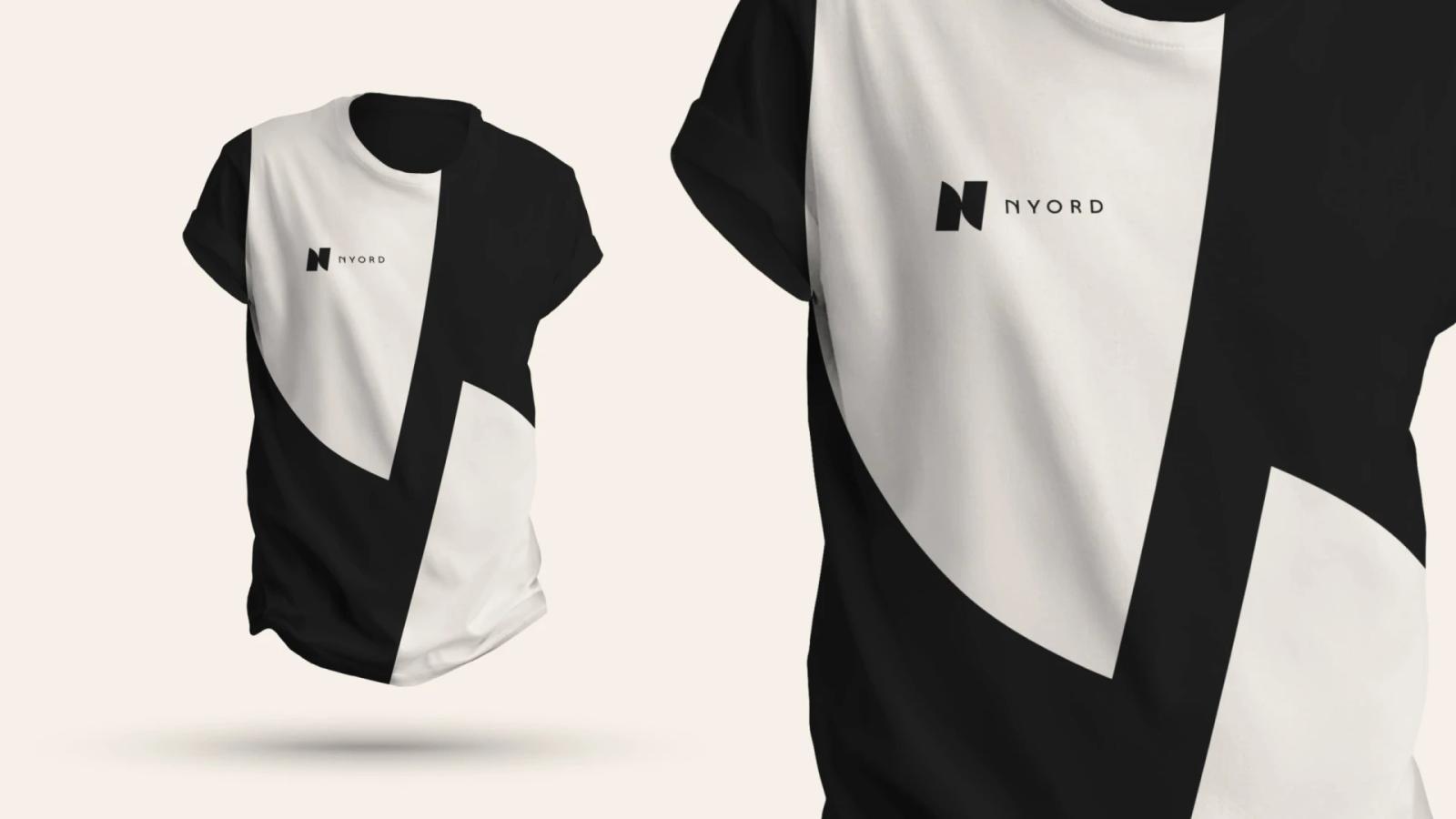 Camiseta con diseño moderno de bloques geométricos en blanco y negro de la marca Nyord mostrando el logotipo minimalista en el pecho y detalle de textura sobre fondo crema suave