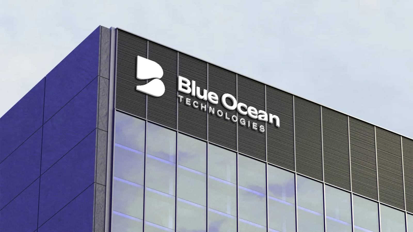 Fachada de edificio corporativo moderno luciendo el logotipo y nombre de Blue Ocean Technologies en relieve blanco sobre paneles metálicos oscuros y ventanas de vidrio azuladas