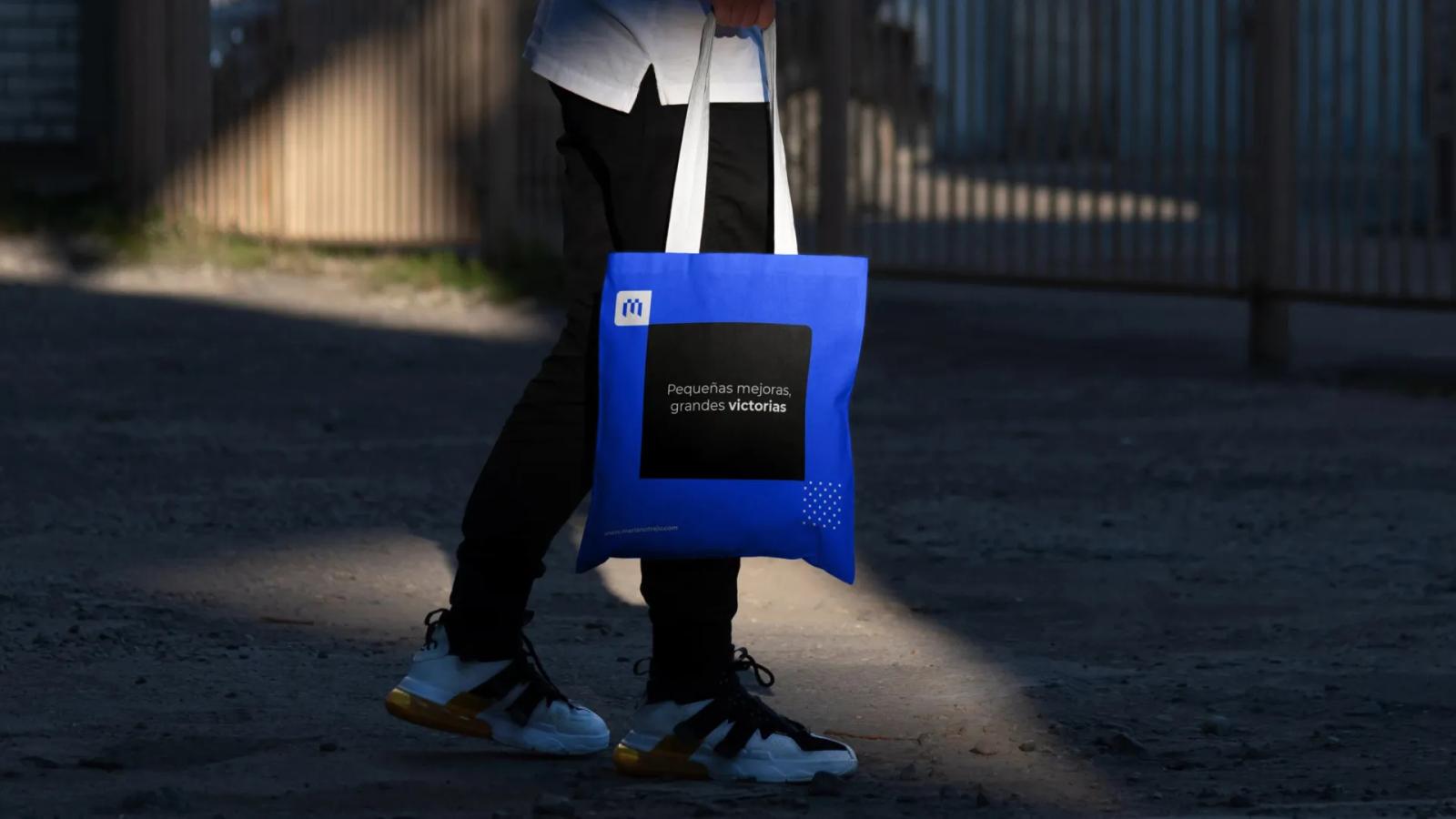 Persona caminando con bolsa reutilizable de la marca en exterior