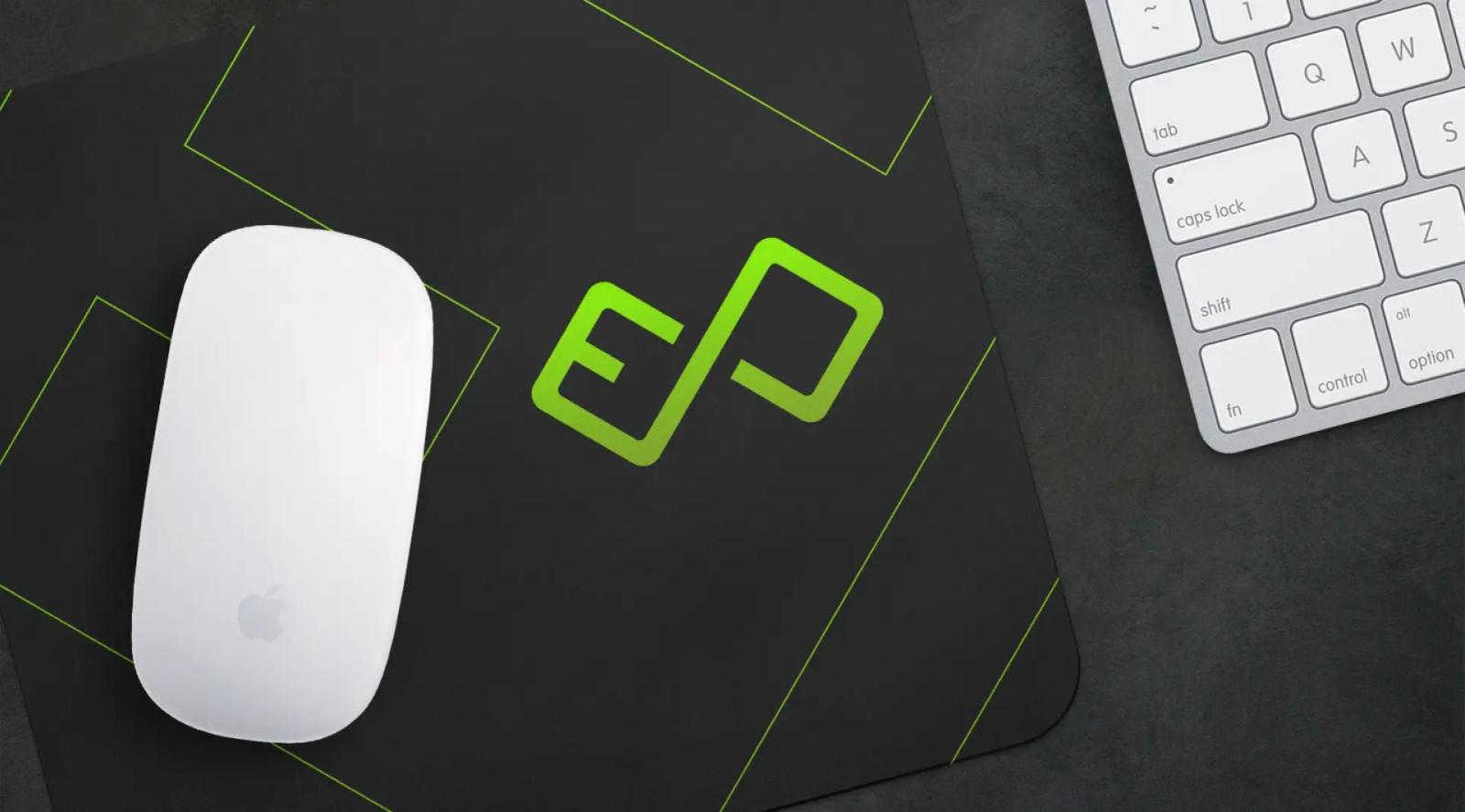 Escritorio minimalista con mouse blanco, teclado y logotipo verde en superficie negra