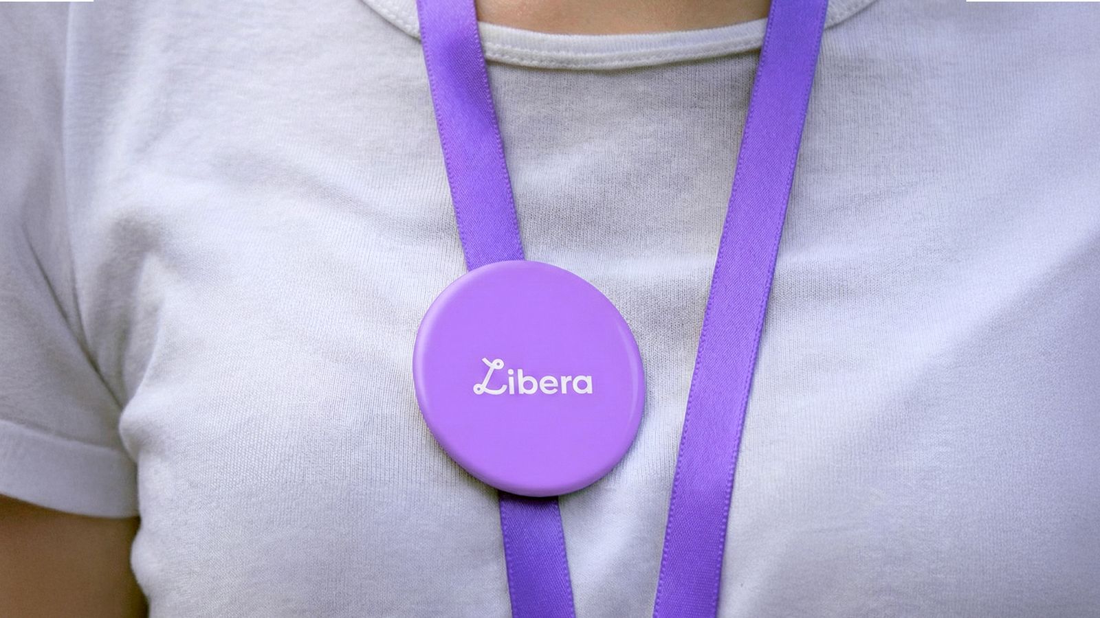 Detalle de pin circular con logotipo colocado sobre vestimenta