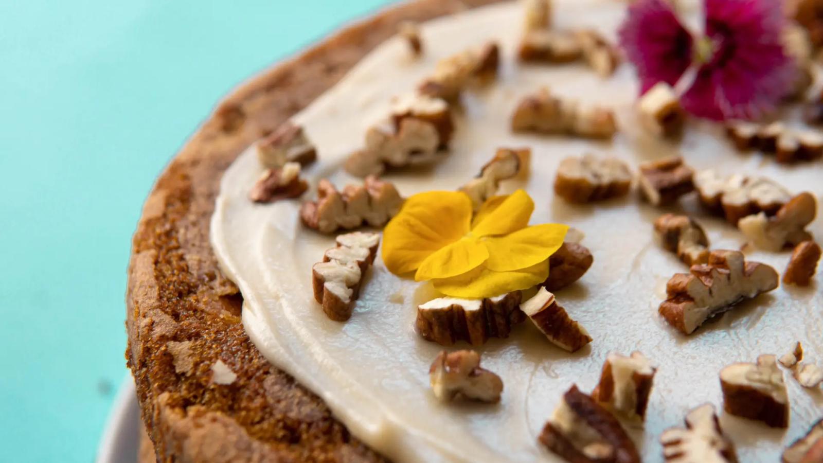 Torta artesanal decorada con flores comestibles y frutos secos