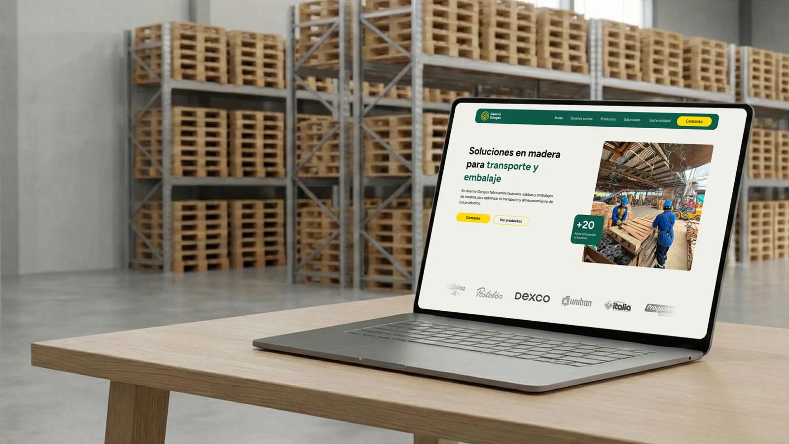 Laptop sobre escritorio mostrando sitio web corporativo en almacén de pallets