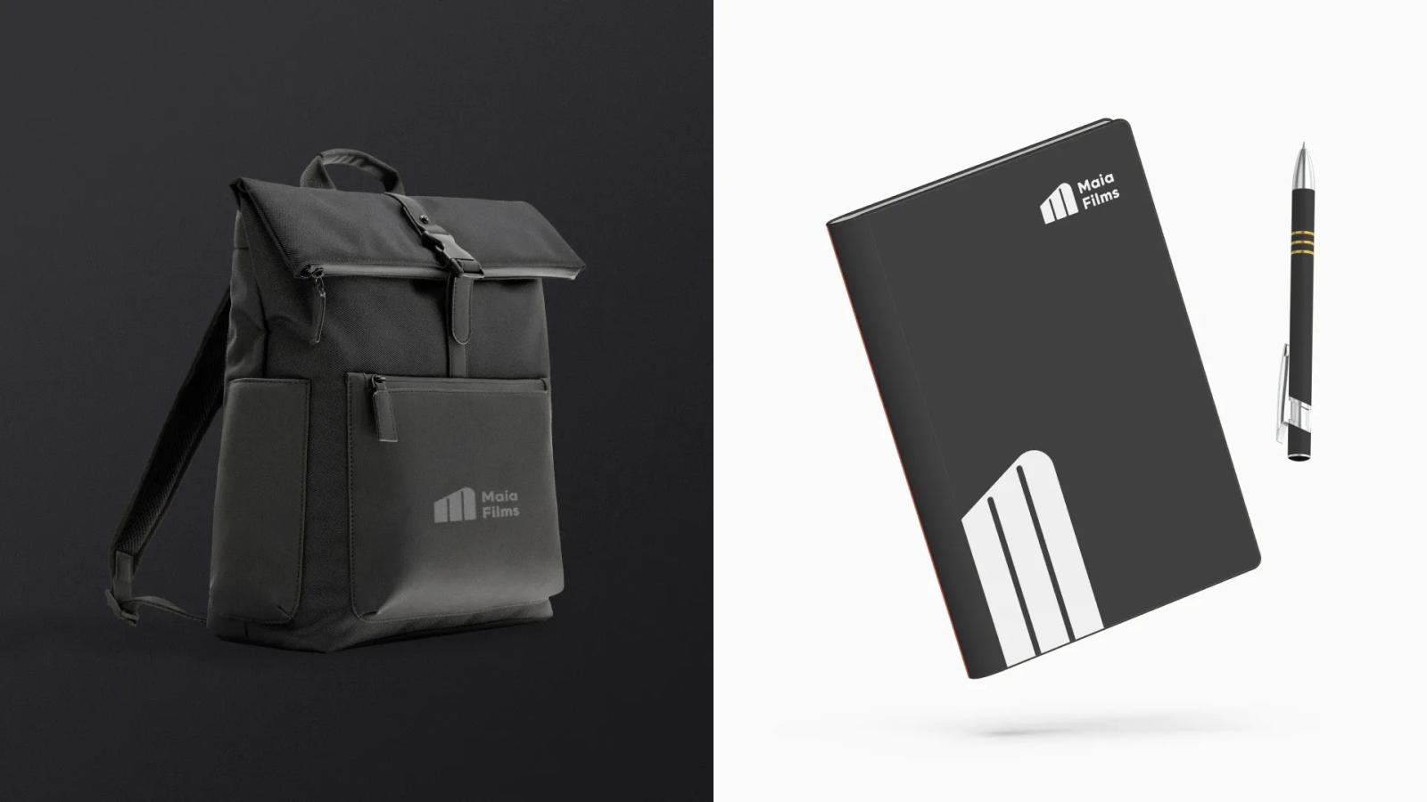 Merchandising corporativo de Maia Films mostrando una mochila negra y una libreta con bolígrafo, ambos luciendo el logotipo de las tres barras verticales y diseño minimalista sobre fondos contrastantes