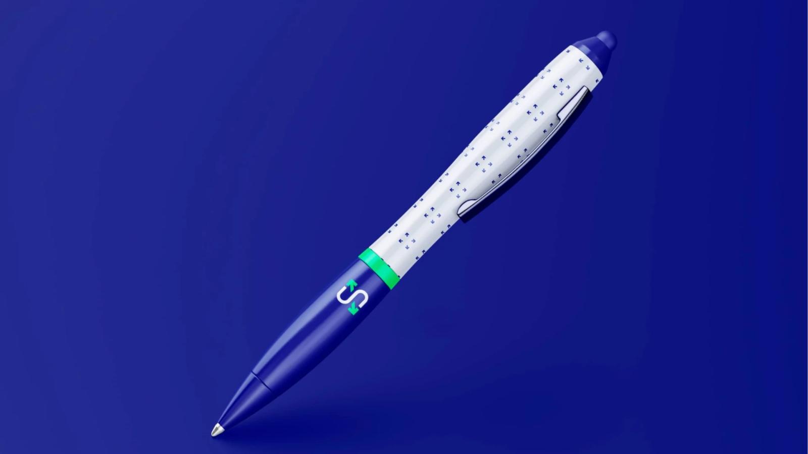 Bolígrafo de diseño corporativo sobre fondo azul, con cuerpo dividido en una sección inferior azul oscuro con el logotipo 'S' y una sección superior blanca decorada con un patrón de pequeñas flechas direccionales azules