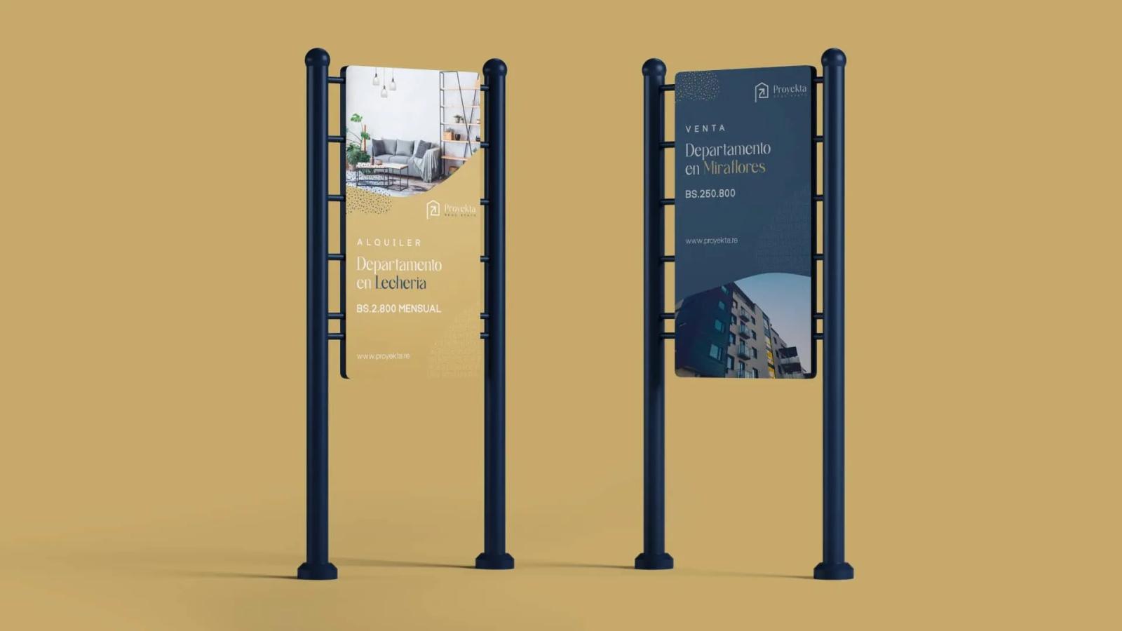 Señalética urbana con tótems publicitarios mostrando piezas gráficas de marca inmobiliaria sobre fondo neutro