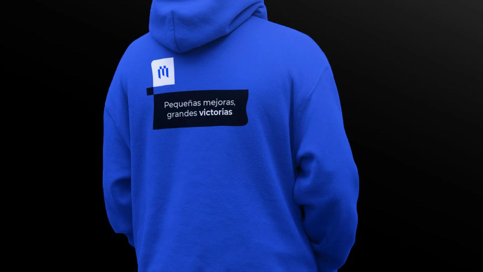 Sudadera azul vista desde la espalda con mensaje tipográfico de la marca